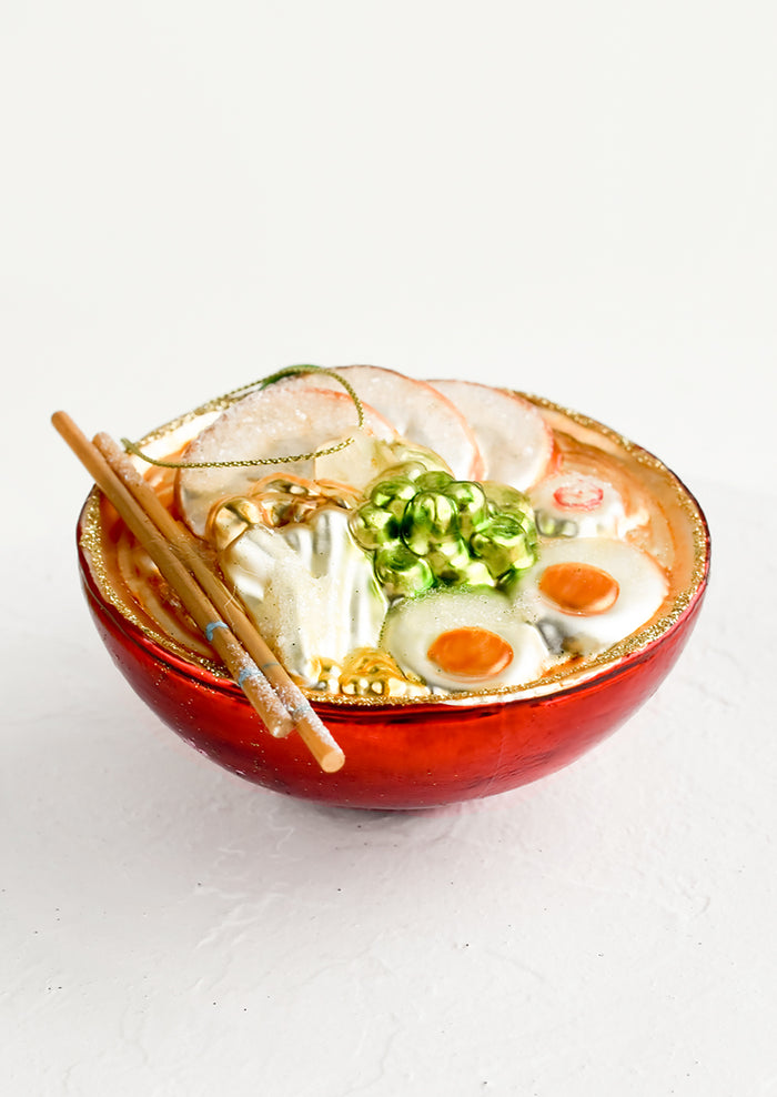 A decorative glass ornament in the shape of ramen noodle bowl.