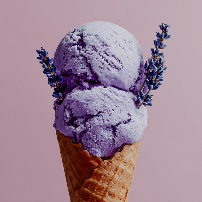Purple lavender ice cream in a cone with lavender flowers on a pink background