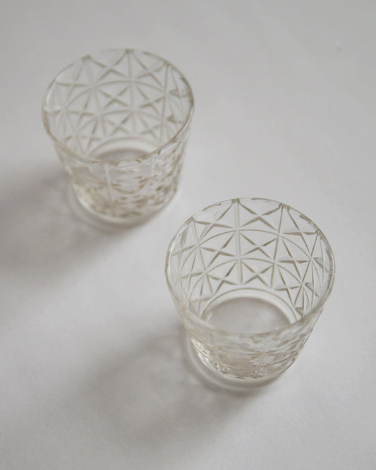 Two mini choko crystal cut glasses diagonally placed.
