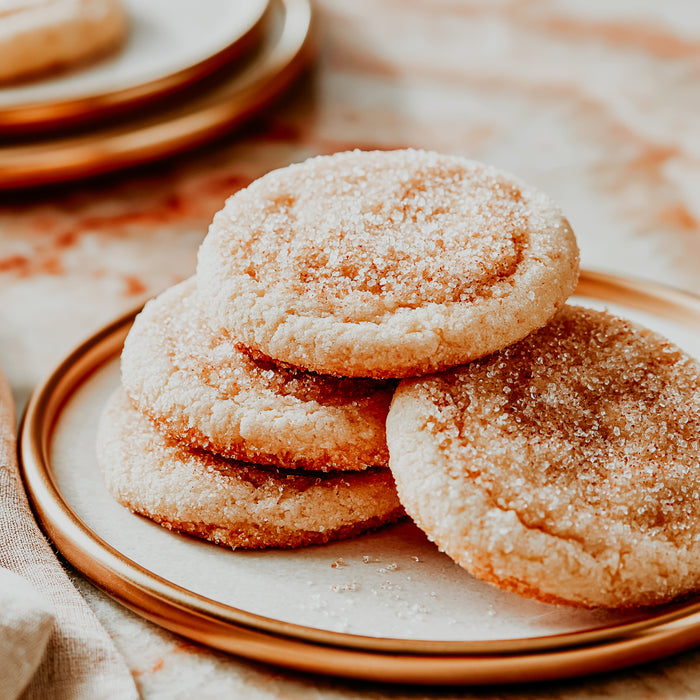 Stack of sugar cookies on a ceramic plate with a soft focus background