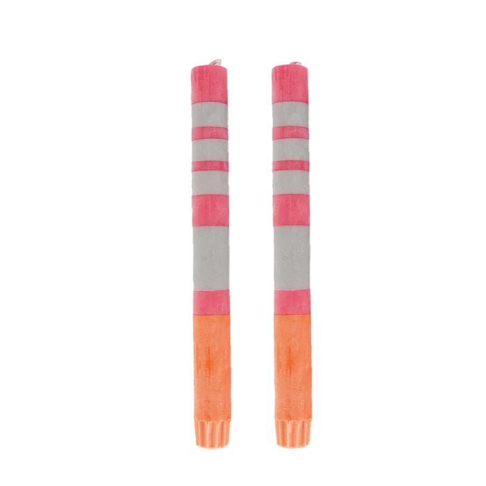 A pair of striped taper candles in pink and orange colors.