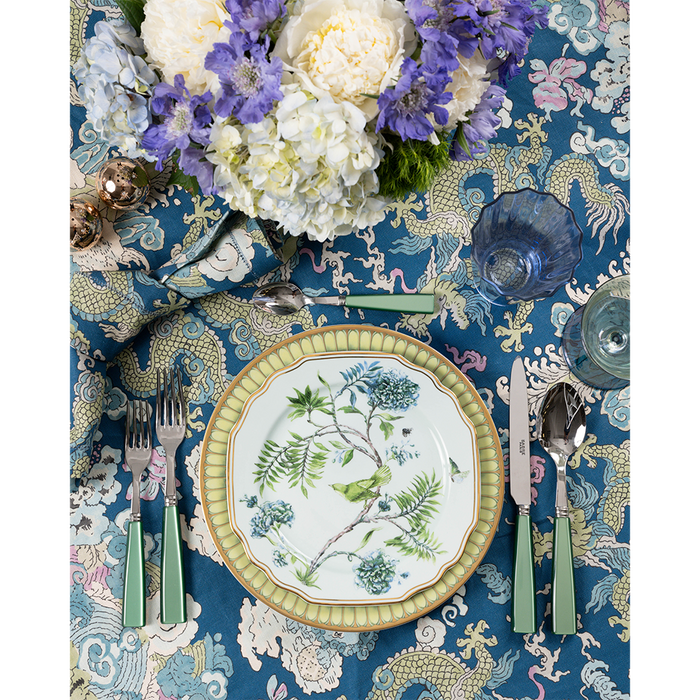 5-piece flatware set with garden green handles alongside floral-patterned plate on blue botanical tablecloth.