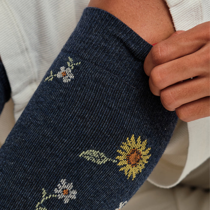 Knee-high compression socks featuring a navy background with sunflower and floral designs.