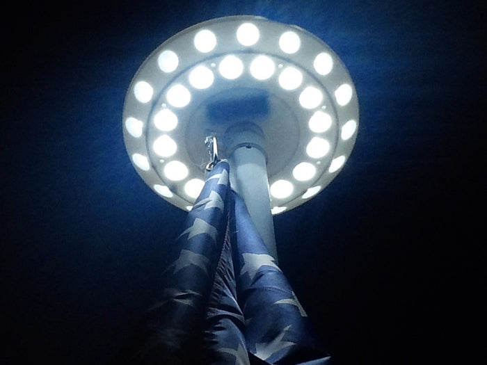 LED solar flagpole top light providing dusk-to-dawn illumination