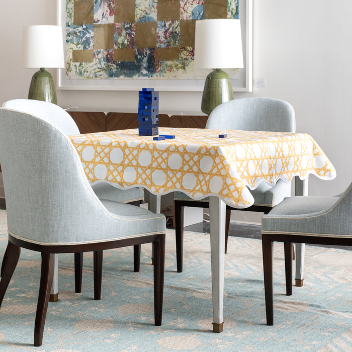 Game table with yellow and white game table topper with blue upholstered accent chairs.