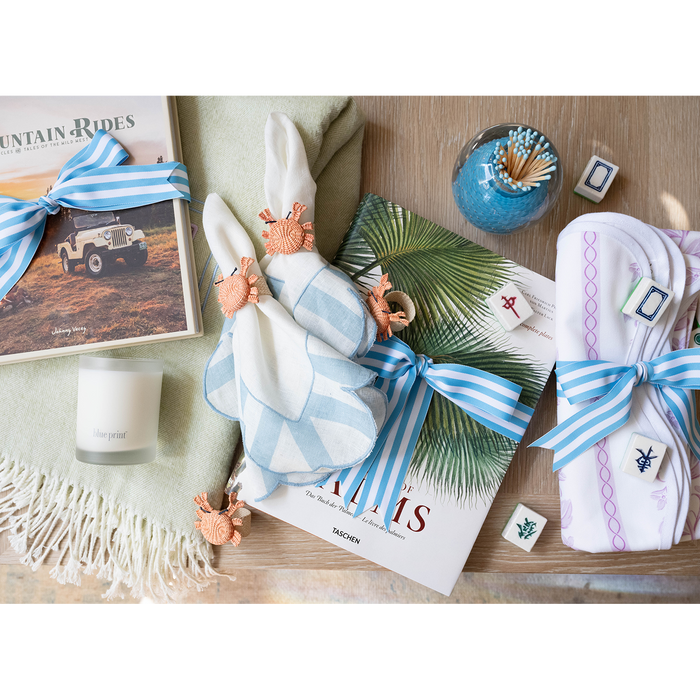 Assorted gifts on a table wrapped in blue and white ribbons