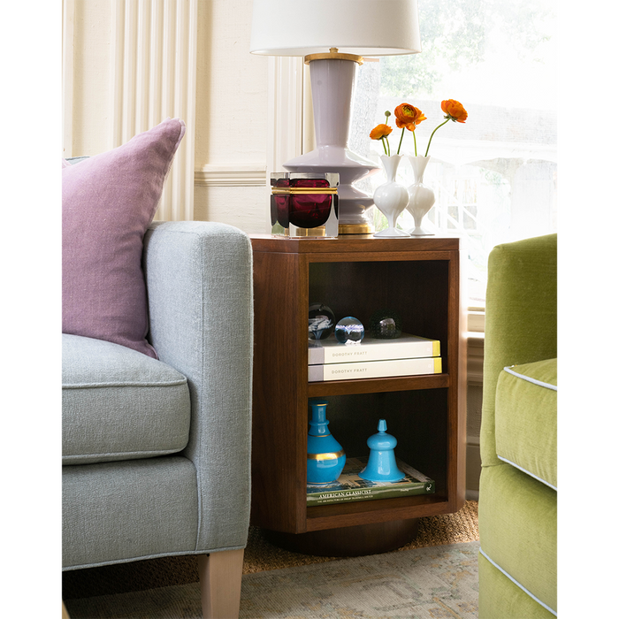 Set of three small white ceramic bud vases with rounded shapes, curved necks, and narrow openings arranged on a wooden side.