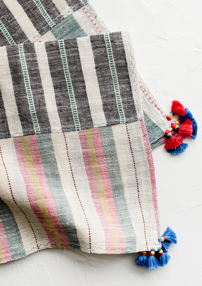 A khadi cotton madras napkin with tassel detailing.