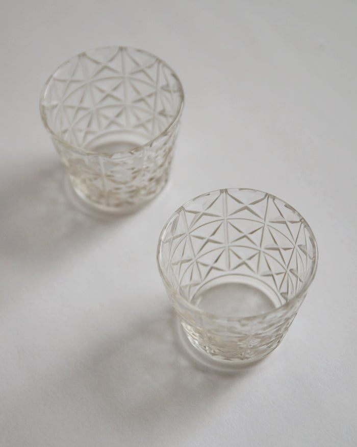 Two mini choko crystal cut glasses diagonally placed.