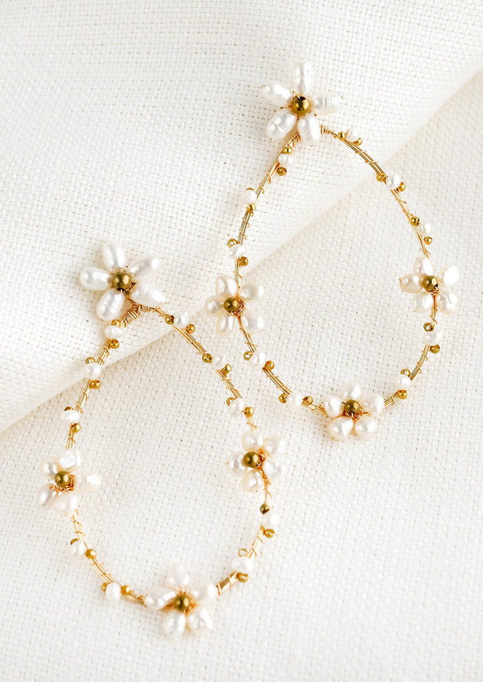 A pair of earrings in large hollow teardrop shape with wire and pearl flower detailing.