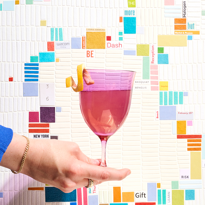 Pink cocktail glass in front of colorful abstract art