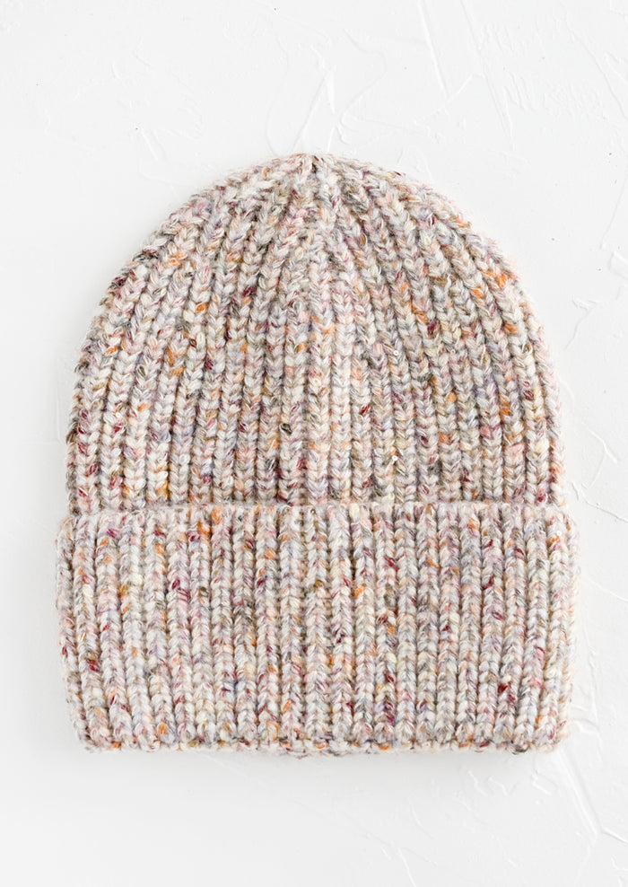 A knit beanie hat with cuffed rim made in multicolor speckled ivory yarn.